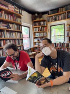 Nebula Award Finalist Benjamin Rosenbaum and SFWA Board Member Curtis Chen enjoy some good lit at a Kansas City bookstore (Prospero&#039;s!) before the Nebula Awards Conference wraps up for another year. (Photo Credit: Kate Ristau, 2025.)