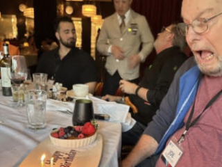 Past SFWA President and Grand Master Joe Haldeman enjoys an early birthday at our 60th Anniversary Nebula Awards Conference. (Photo Credit: Kate Ristau, 2025.)
