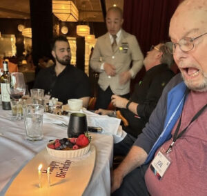 Past SFWA President and Grand Master Joe Haldeman enjoys an early birthday at our 60th Anniversary Nebula Awards Conference. (Photo Credit: Kate Ristau, 2025.)
