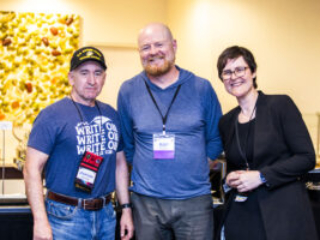 SFWA CFO Jonathan Brazee (left) and President Kate Ristau (right) celebrate Nebula Finalist Ray Nayler (center). (Photo Credit: Kaitrin Acuna, 2025.)