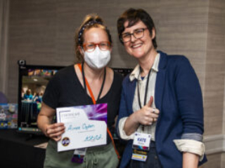 Aimee Ogden receives a certificate of appreciation from SFWA President Kate Ristau. (Photo Credit: Kaitrin Acuna, 2025.)