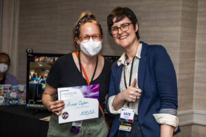 Aimee Ogden receives a certificate of appreciation from SFWA President Kate Ristau. (Photo Credit: Kaitrin Acuna, 2025.)
