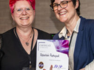 Rebekah Postupak receives a certificate of appreciation from SFWA President Kate Ristau. (Photo Credit: Kaitrin Acuna, 2025.)