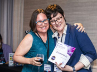 Christine Hanolsy receives a certificate of appreciation from SFWA President Kate Ristau. (Photo Credit: Kaitrin Acuna, 2025.)