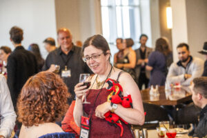 Jennifer Povey and a glorious red dragon mingle at our 60th Anniversary Nebula Awards Conference. (Photo Credit: Kaitrin Acuna, 2025.)