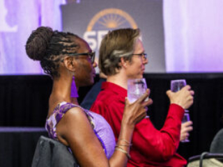 SFWA Executive Director Isis Asare and SFWA Vice-President Anthony Eichenlaub enjoy the Nebula Awards Ceremony. (Photo Credit: Kaitrin Acuna, 2025.)