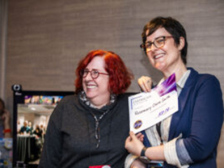 Rosemary Claire Smith receives a certificate of appreciation from SFWA President Kate Ristau. (Photo Credit: Kaitrin Acuna, 2025.)