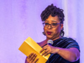 Toastmaster Erin Roberts, theatrically poised with an award-winner envelope at our 60th Anniversary Nebula Awards Ceremony. (Photo Credit: Kaitrin Acuna, 2025.)