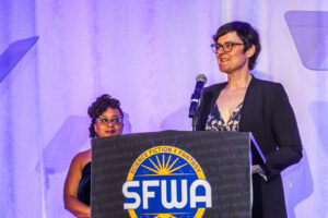 Toastmaster Erin Roberts and SFWA President Kate Ristau, co-presenting at the Nebula Awards Ceremony. (Photo Credit: Kaitrin Acuna, 2025.)