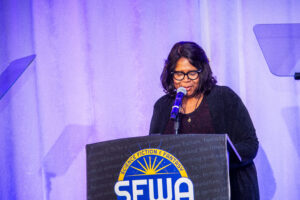 SFWA Board Member Christine Taylor-Butler (Director-at-Large) introduces an award at the 60th Anniversary Nebula Awards Ceremony. (Photo Credit: Kaitrin Acuna, 2025.)