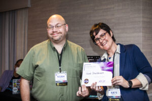 Noah Sturdevant receives a certificate of appreciation from SFWA President Kate Ristau. (Photo Credit: Kaitrin Acuna, 2025.)