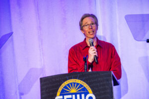 SFWA Vice President Anthony Eichenlaub introduces an award at our 60th Anniversary Nebula Awards Ceremony, held on Saturday, June 7. (Photo Credit: Kaitrin Acuna, 2025.)