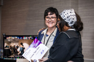 Christine Taylor-Butler receives a certificate of appreciation from SFWA President Kate Ristau. (Photo Credit: Kaitrin Acuna, 2025.)