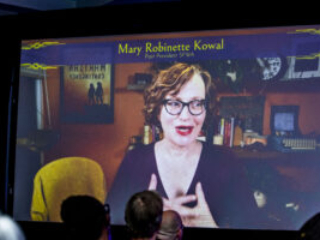 Past SFWA President Mary Robinette Kowal surprises 60th Anniversary Nebula Awards Ceremony attendees with an online cameo appearance. (Photo Credit: Kaitrin Acuna, 2025.)