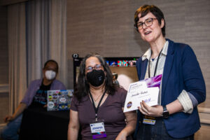 Jennifer Hudak receives a certificate of appreciation from SFWA President Kate Ristau. (Photo Credit: Kaitrin Acuna, 2025.)