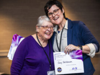 Gay Haldeman receives a certificate of appreciation from SFWA President Kate Ristau. (Photo Credit: Kaitrin Acuna, 2025.)