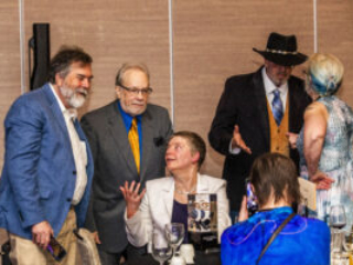 SFWA Grand Master Nicola Griffith holds forth with guests at the Nebula Awards Ceremony on June 7. (Photo Credit: Kaitrin Acuna, 2025.)