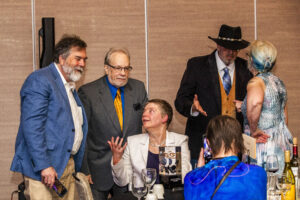 SFWA Grand Master Nicola Griffith holds forth with guests at the Nebula Awards Ceremony on June 7. (Photo Credit: Kaitrin Acuna, 2025.)