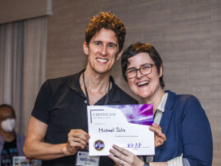 Michael Solis receives a certificate of appreciation from SFWA President Kate Ristau. (Photo Credit: Kaitrin Acuna, 2025.)