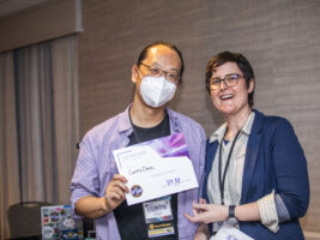 Curtis Chen receives a certificate of appreciation from SFWA President Kate Ristau. (Photo Credit: Kaitrin Acuna, 2025.)