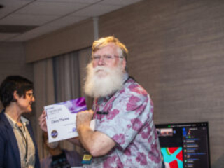Chris Marble receives a certificate of appreciation from SFWA President Kate Ristau. (Photo Credit: Kaitrin Acuna, 2025.)