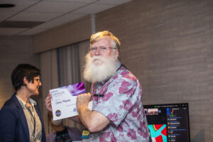 Chris Marble receives a certificate of appreciation from SFWA President Kate Ristau. (Photo Credit: Kaitrin Acuna, 2025.)