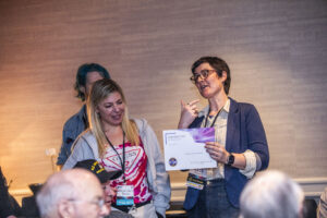 Katelyn (Kat) Brehm receives a certificate of appreciation from SFWA President Kate Ristau. (Photo Credit: Kaitrin Acuna, 2025.)