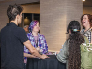 Panelists Michael Solis and Kelsey Josephson chat with other attendees during opening events at our 60th Anniversary Nebula Awards Conference. (Photo Credit: Kaitrin Acuna, 2025.)