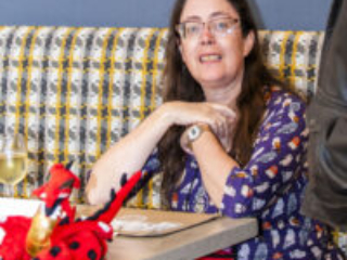 Nebula Finalist Jennifer Povey, with dragon accompaniment at our 60th Anniversary Nebula Awards Conference. (Photo Credit: Kaitrin Acuna, 2025.)