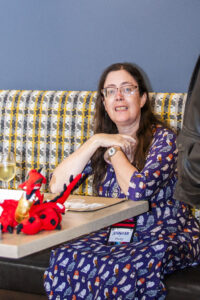 Nebula Finalist Jennifer Povey, with dragon accompaniment at our 60th Anniversary Nebula Awards Conference. (Photo Credit: Kaitrin Acuna, 2025.)