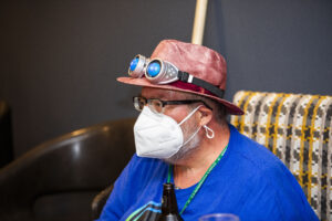 A Nebula attendee comes prepared! SFWA Board Member Steven D. Brewer with goggles and mask at the ready. (Photo Credit: Kaitrin Acuna, 2025.)