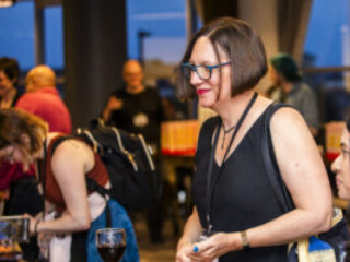Nebula Award Finalist Christine Hanolsy enjoying a serene moment, surrounded by happy conference-goers. (Photo Credit: Kaitrin Acuna, 2025)