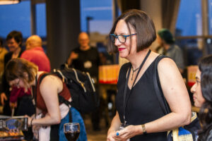 Nebula Award Finalist Christine Hanolsy enjoying a serene moment, surrounded by happy conference-goers. (Photo Credit: Kaitrin Acuna, 2025)