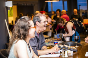 Joy shared between networking authors, including R. R. Corvi. (Photo Credit: Kaitrin Acuna, 2025.)